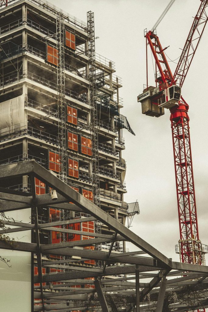 Building under construction with a red tower crane in London