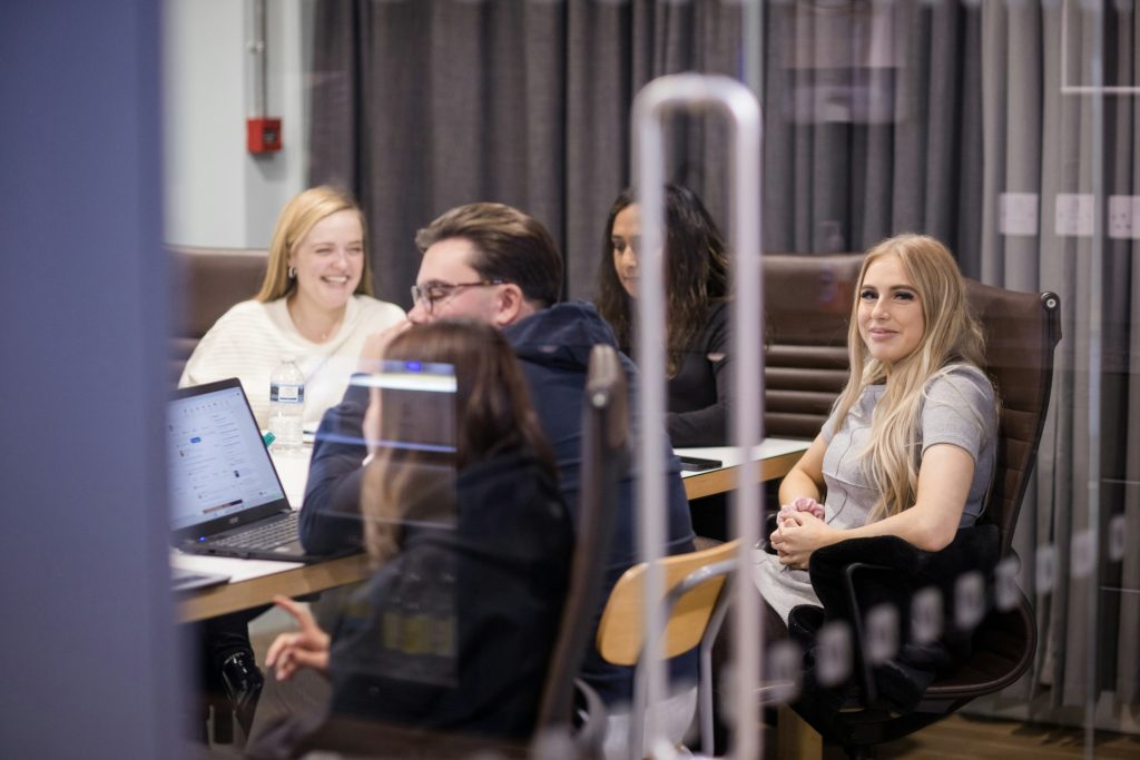 Team working with laptops around a meeting table in a London office